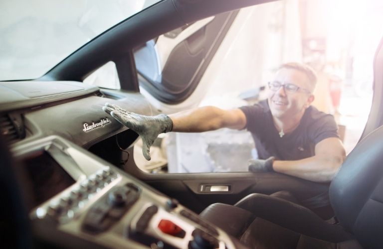 a technician detailing the interior of a Lamborghini